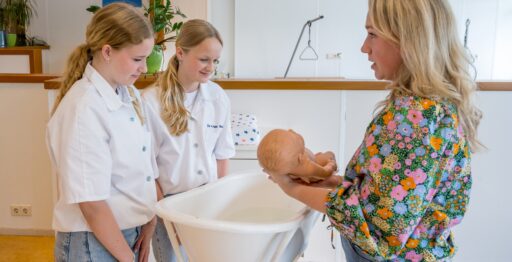 Docent laat zien hoe je een baby in bad moet doen