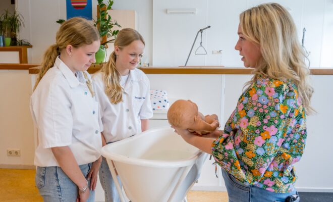 Docent laat zien hoe je een baby in bad moet doen
