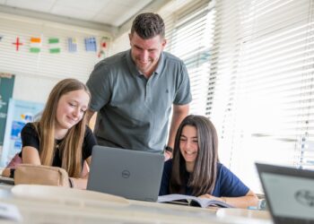 Docent helpt leerlingen in de les